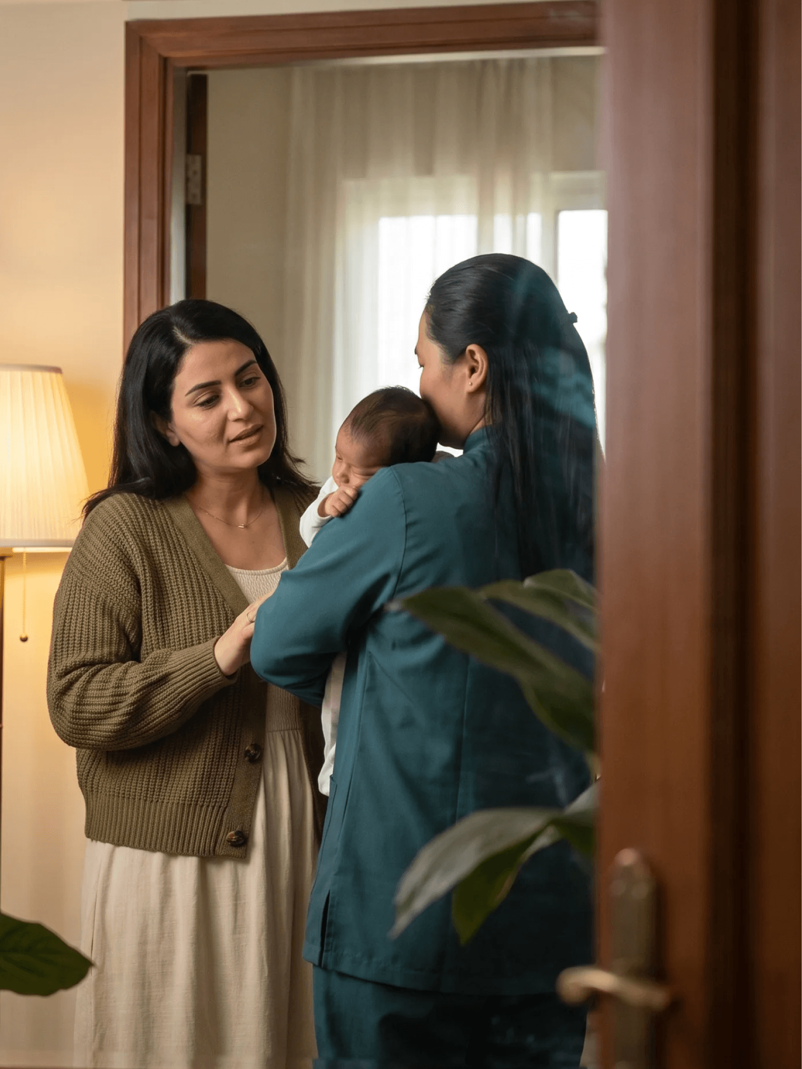 Mother welcoming a DarDoc caregiver holding a newborn